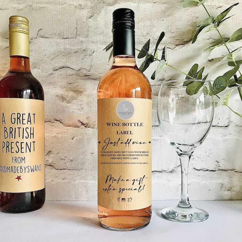 Puede incluir: Una botella de vino con una etiqueta de papel color canela con el texto WINE BOTTLE LABEL Just add wine STRAIGHT BODY BOTTLES WITH HIGH SHOULDERS ARE RECOMMENDED FOR THIS SIZE WINE LABEL Make a gift extra special e iconos sociales.