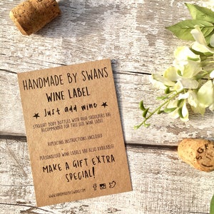 May include: A brown paper wine label with the text "HANDMADE BY SWANS WINE LABEL" and "Just add wine". The label also includes instructions for replacing the label and information about personalized wine labels.