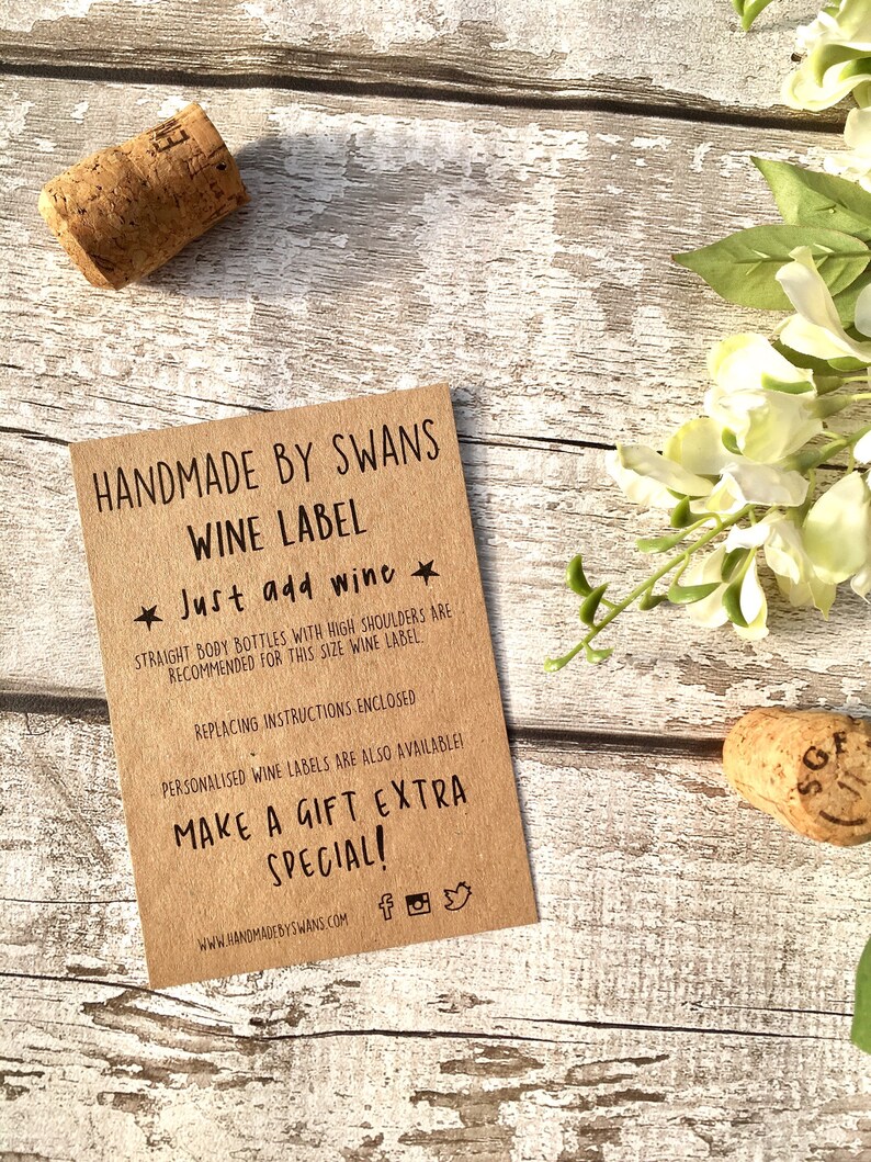 May include: A brown paper wine label with the text "HANDMADE BY SWANS WINE LABEL" and "Just add wine". The label also includes instructions for replacing the label and information about personalized wine labels.