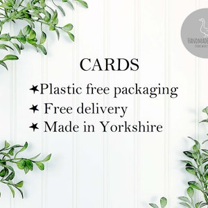Puede incluir: Fondo blanco con ramas verdes frondosas a cada lado. El texto "CARDS" est&aacute; en negro. Debajo del texto hay tres vi&ntilde;etas con el siguiente texto: "Plastic free packaging", "Free delivery", "Made in Yorkshire". El texto "HANDMADE BY SWANS" est&aacute; en un c&iacute;rculo gris con un contorno blanco y una silueta blanca de un cisne dentro del c&iacute;rculo.