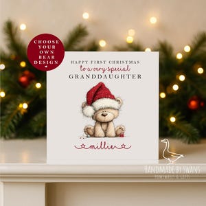 以下が含まれることがあります： サンタ帽をかぶったテディベアのクリスマスカード。「Happy First Christmas to a very special Granddaughter」と「millie」という名前が書かれています。赤い丸には「Choose Your Own Bear Design」と書かれています。