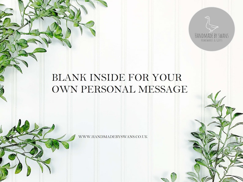May include: White background with green leafy branches on either side. The text "BLANK INSIDE FOR YOUR OWN PERSONAL MESSAGE" is in the center of the image. Below the text is the website address "www.handmadebyswans.co.uk". In the upper right corner is a gray circle with a white outline and a white line drawing of a goose. The text "HANDMADE BY SWANS HOMEWARES & GIFTS" is inside the circle.