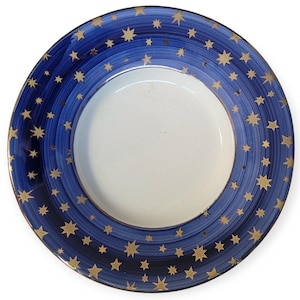 May include: A blue and gold ceramic plate with a star pattern. The plate has a white centre and a blue rim with gold stars.