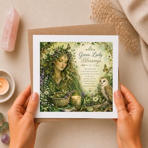 May include: A square greeting card featuring an illustration of a woman with long hair adorned with flowers, surrounded by greenery, a bowl, a candle, and an owl. The text reads Green Lady Blessings and includes a poem about nature and earth.