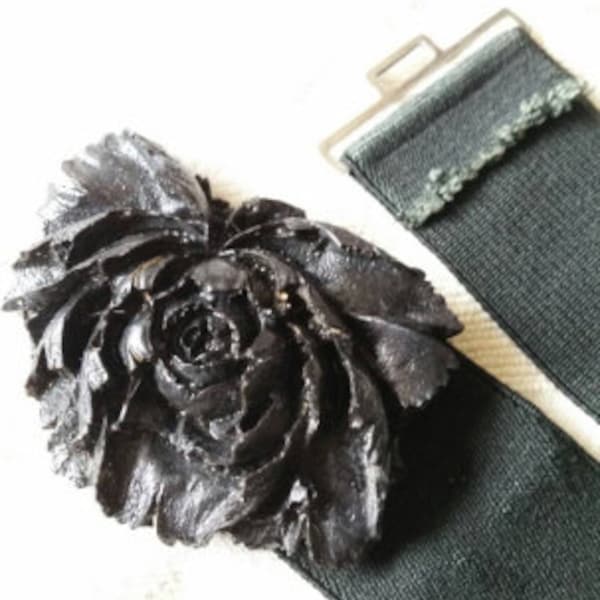 Black resin rose buckle on stretch elastane belt with silvertone clasp