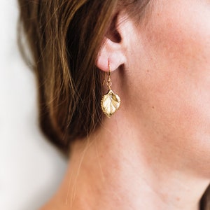 Pu&ograve; includere: Orecchini a foglia d'oro con un design delicato e dettagliato. Gli orecchini sono di stile pendente e hanno una chiusura a gancio.