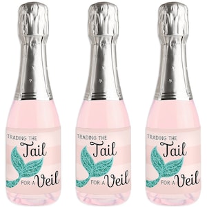 May include: Three mini champagne bottles with labels that say "Trading the Tail for a Veil" with a mermaid tail graphic. The labels are pink and white with teal glitter accents.