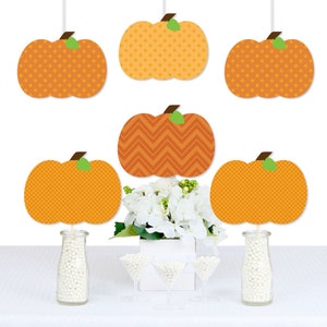 May include: Set of six orange and brown pumpkin cutouts with different patterns. The pumpkins are hanging from strings and are arranged in a row. The pumpkins are perfect for decorating for a fall party or event.