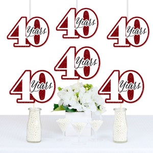 May include: Six red glitter 40 Years table toppers. The toppers are white with red glitter and black text. The toppers are on sticks and are perfect for a 40th anniversary party.