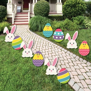 May include: A set of eight Easter-themed yard decorations. The decorations include bunnies, chicks, and eggs with colorful patterns. The decorations are made of cardboard and are designed to be staked into the ground.