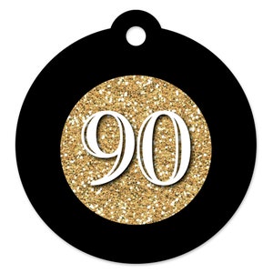 May include: Black and gold round tag with the number 90 in white on a gold glitter background.