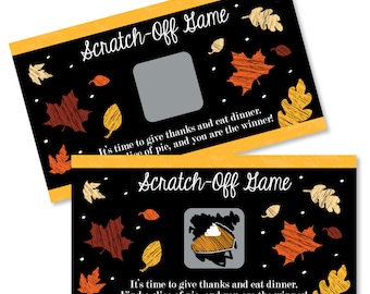 May include: Two black and orange scratch-off cards with a fall theme. The cards have a black background with orange and brown leaves and the text "Scratch-Off Game". The text "It's time to give thanks and eat dinner. Find a slice of pie, and you are the winner!" is on both cards.