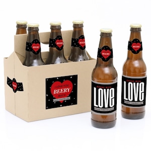 May include: Six brown beer bottles with black and red Valentine's Day themed labels. The labels say "I love you Beery Much" and "Drunk with Love".