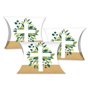 May include: Three white pillow boxes with a cross design. Each box features a white cross surrounded by green leaves and foliage. The bottom of each box has a tan plaid pattern.