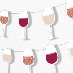 May include: A string of paper wine glasses in various colors, including red, white, and rose gold glitter. The glasses are strung on a thin, white string against a white background. The wine glasses are a festive decoration.