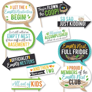 May include: A set of 10 colorful photo booth props with humorous sayings about empty nesting. The props feature a variety of shapes, including speech bubbles, arrows, and signs. The text on the props includes phrases like "Let the Empty Nestivities Begin!" and "Mission Accomplished!"
