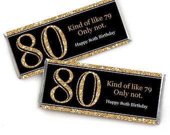 May include: Two gold and black chocolate bar wrappers with the number 80 and the text "Kind of like 79 Only not. Happy 80th Birthday".