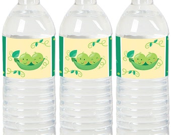 May include: Three clear plastic water bottles with yellow and green labels featuring a cartoon image of two peas in a pod. The labels have the text "We're Peas in a Pod".