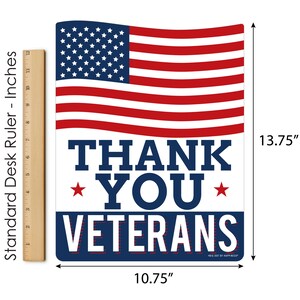 Puede incluir: Una bandera estadounidense roja, blanca y azul con las palabras "Thank You Veterans" en texto azul con estrellas blancas a cada lado de la palabra "You". El letrero tiene 10,75 pulgadas de ancho y 13,75 pulgadas de alto.