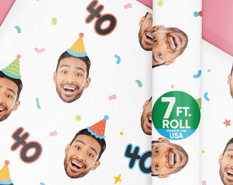 May include: White wrapping paper with a repeating pattern of a smiling face wearing a party hat, the number 40, and confetti. A roll of the paper is visible, with a green sticker that says "7 FT. ROLL MADE IN THE USA."