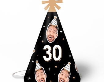 May include: A black cone-shaped party hat featuring a large white number 30 in the center. The hat is decorated with a repeating pattern of a smiling person's face wearing a small party hat, interspersed with small gold stars and white sparkles.