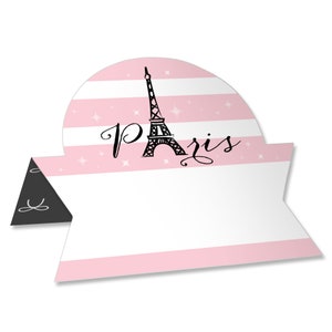 May include: Pink and white striped place card with a black and white illustration of the Eiffel Tower and the word "Paris".