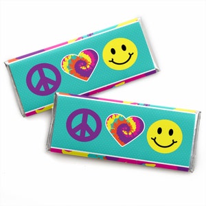 May include: Two rectangular candy bar wrappers featuring a teal background with a white polka dot pattern. Each wrapper displays a purple peace sign, a tie-dye heart in shades of orange, yellow, and purple, and a yellow smiley face icon.