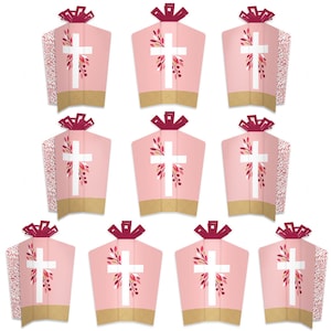 May include: Ten pink and gold table toppers with a white cross and floral design. The toppers are shaped like a church steeple with a burgundy bow.