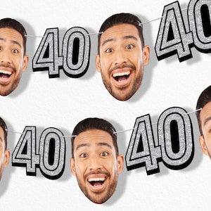May include: A banner featuring the number "40" in silver glitter with a black outline, interspersed with images of a smiling person's face. The banner is strung on a thin white string, perfect for a birthday celebration.