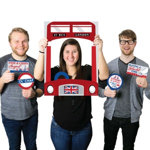 May include: A red double-decker bus photo booth prop with a cutout for a face. The bus has the words "27 BUS" and "LONDON" on the front. There are three props: a sign that says "FISH & CHIPS Anyone?", a sign that says "OL' CHAP", and a sign that says "LONDON IS ALWAYS A Good Idea".