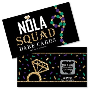 May include: A black and gold card with the text "NOLA SQUAD DARE CARDS" and a gold diamond ring with a green and purple confetti background. The card has a scratch-off area with the text "TAKE A SHOT of the Bride's choosing" and "SCRATCH For your dare".