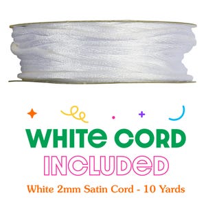 May include: A spool of white satin cord. The text "WHITE CORD INCLUDED" is displayed in green and pink. The text "White 2mm Satin Cord - 10 Yards" is also visible.