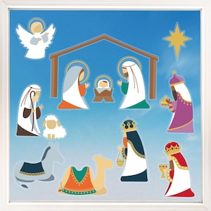 May include: A framed Christmas nativity scene with a blue sky background. The scene includes an angel, the holy family, the three wise men, a donkey, a camel, and a sheep. The figures are in a cartoon style with bright colors.