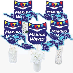 May include: Six blue and white table centerpieces with the text "Making Waves" and a swimmer silhouette. The centerpieces are decorated with red, yellow, and blue pennants.