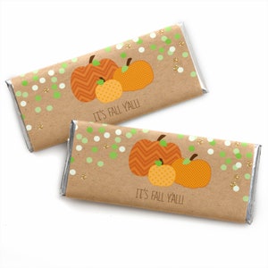May include: Two rectangular chocolate bars wrapped in brown paper featuring a graphic of three orange pumpkins with chevron and grid patterns. The design includes green and white polka dots, gold glitter accents, and the text IT'S FALL Y'ALL!