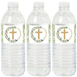 May include: Three clear plastic water bottles with white labels. Each label features a gold circle with a green leafy wreath and a gold cross in the center.