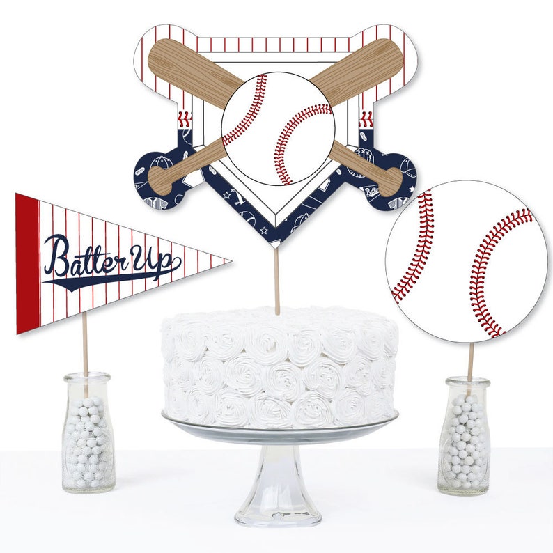 May include: Baseball themed cake toppers with a pennant flag that says "Batter Up" in a vintage style font. The toppers feature a baseball, bats, and a home plate.
