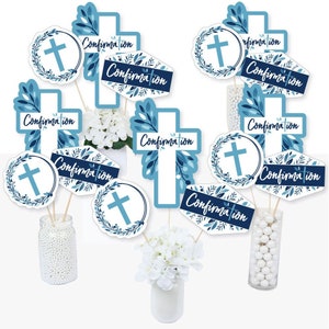 May include: Blue and white confirmation party centerpiece sticks with a cross and floral designs. The sticks feature the word "Confirmation" in a cursive font.