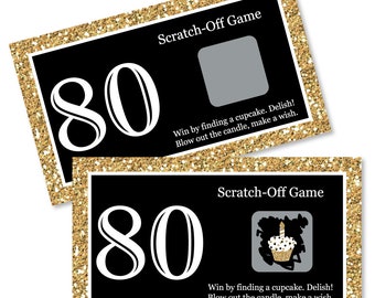 May include: Two black and gold scratch-off game cards with the number 80 printed in white. The cards have a gold glitter background and the text "Scratch-Off Game" and "Win by finding a cupcake. Delish! Blow out the candle, make a wish." printed in white.
