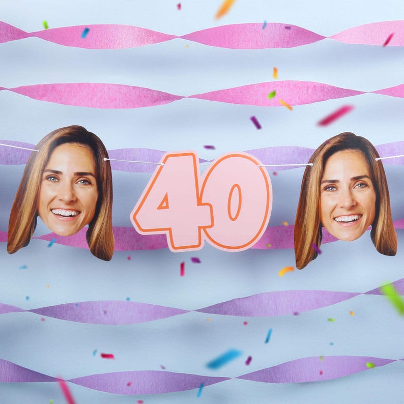 May include: A festive banner with the number "40" in pink, flanked by two smiling faces. The background features pink streamers, confetti, and a light blue backdrop, creating a celebratory atmosphere.