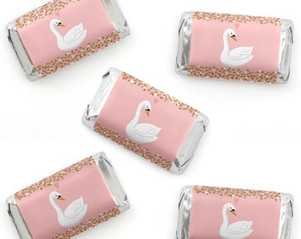 May include: Five rectangular chocolate bars wrapped in silver foil with custom pink paper labels. Each label features a white swan illustration, a small pink heart, and gold glitter-style accents along the top and bottom edges of the wrapper.