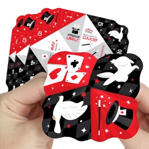 May include: A red and black magic themed fortune teller with a white dove, a rabbit, a magic wand, a top hat, and playing cards. The fortune teller has the words "Seems Likely" and "Signs point to CAKE!" on it.