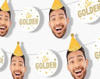 May include: A festive garland featuring smiling faces wearing gold party hats, interspersed with white circular cutouts. The cutouts display the text "So GOLDEN" in gold glitter with star accents, strung on a white string.