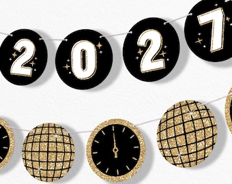 May include: A decorative banner featuring circular black cutouts strung together. The top row displays the white numbers 2, 0, 2, 7 with gold glitter outlines. The bottom row features gold glitter disco balls and a black clock face with gold hands.