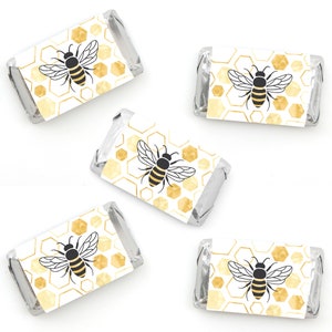 May include: Five gold and white favor boxes with a bee and honeycomb design. The boxes are perfect for a bee-themed party or event.