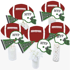 May include: Football party centerpiece sticks with green and black accents. The sticks feature footballs, helmets, and flags with the text "Touch Down!" and "MVP".