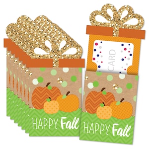 May include: Set of 8 gift card holders with a fall theme. The holders are decorated with pumpkins, polka dots, and the words "Happy Fall". Each holder has a slot for a gift card and a gold glitter bow.