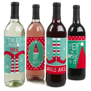 May include: Four wine bottles with festive Christmas elf themed labels. The labels feature red and green colors with white snowflakes and text that reads "This Elf Runs on Wine", "Have Your Elf a Merry Little Christmas", "Jingle Juice", and "The Elf Made Me Drink It".