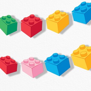 May include: A colorful garland of toy building blocks in green, red, yellow, pink, and blue. Each block is connected by a thin, silver string, creating a playful and decorative chain. The blocks have a classic design with rounded studs.