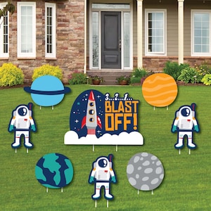 May include: A set of 8 outdoor yard signs featuring a rocket, astronauts, planets, and the text "3...2...1... BLAST OFF!" The signs are printed on cardboard and have stakes for easy placement in the ground.